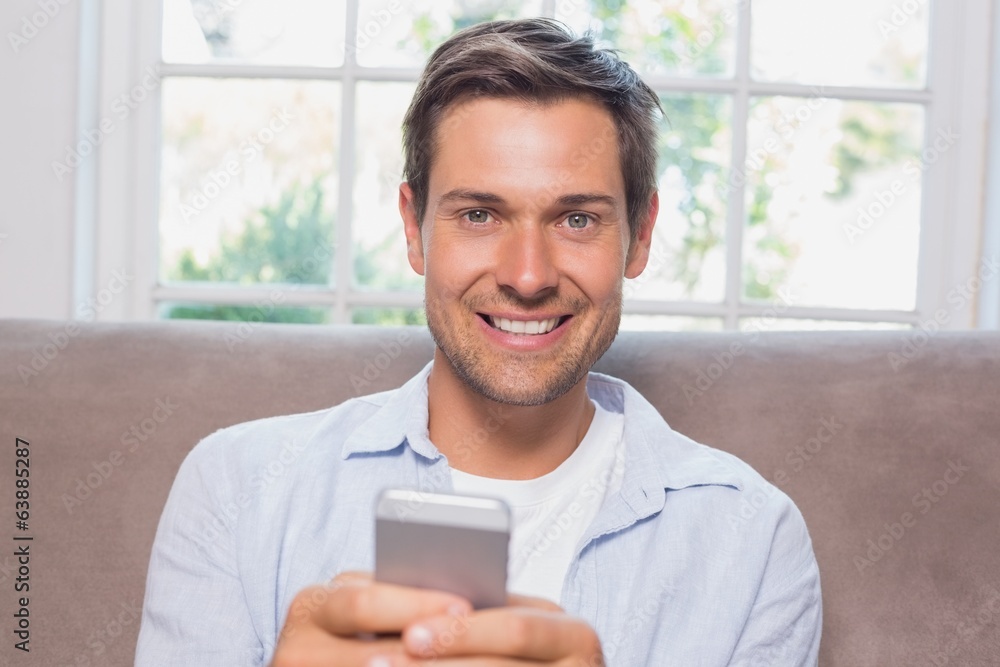 Portrait of a casual man reading text message on sofa Portrait of a casual man reading text message on sofa