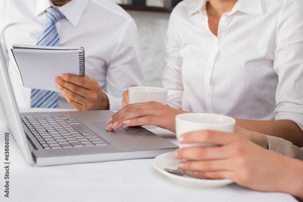Mid section of three business people using laptop Mid section of three business people using laptop