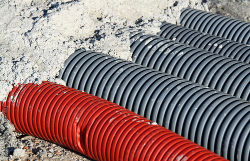 pvc corrugated hose and four gray pipes for laying electric cabl photo