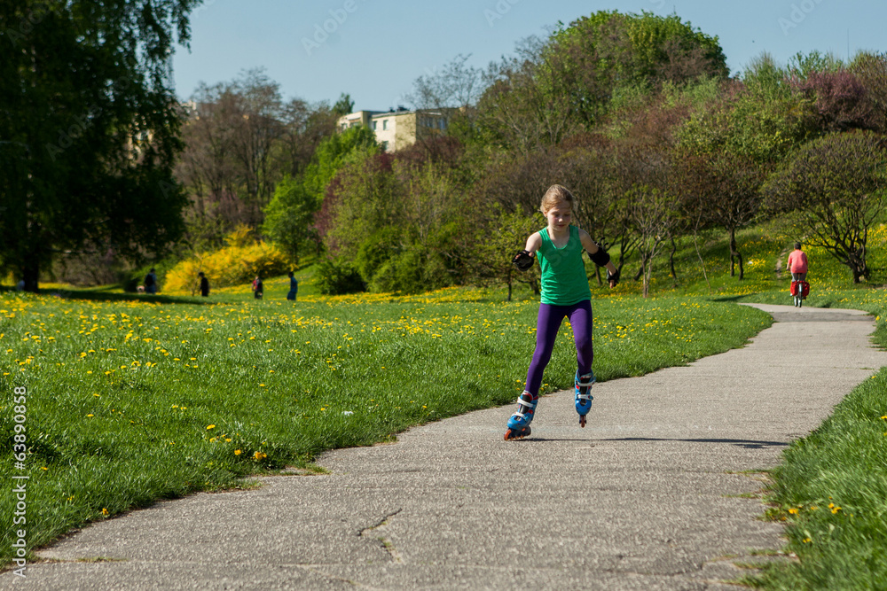Fototapeta premium girl on inline skates learns to ride 