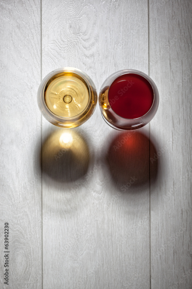 Glasses of red and white wine on wooden table