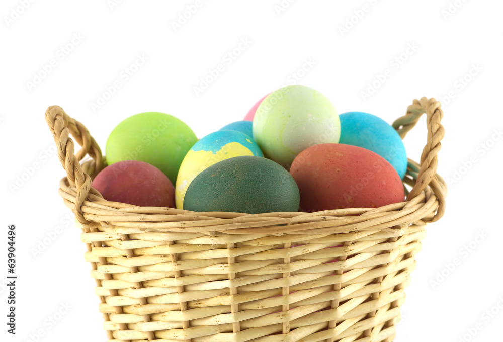 Color Easter eggs in brown basket side view isolated Color Easter eggs in brown basket side view isolated
