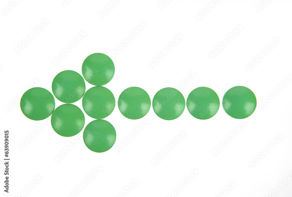 Arrow of green pills on white background
