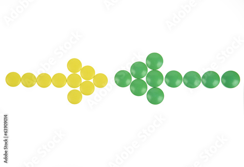 Arrow of yellow and green pills on white background