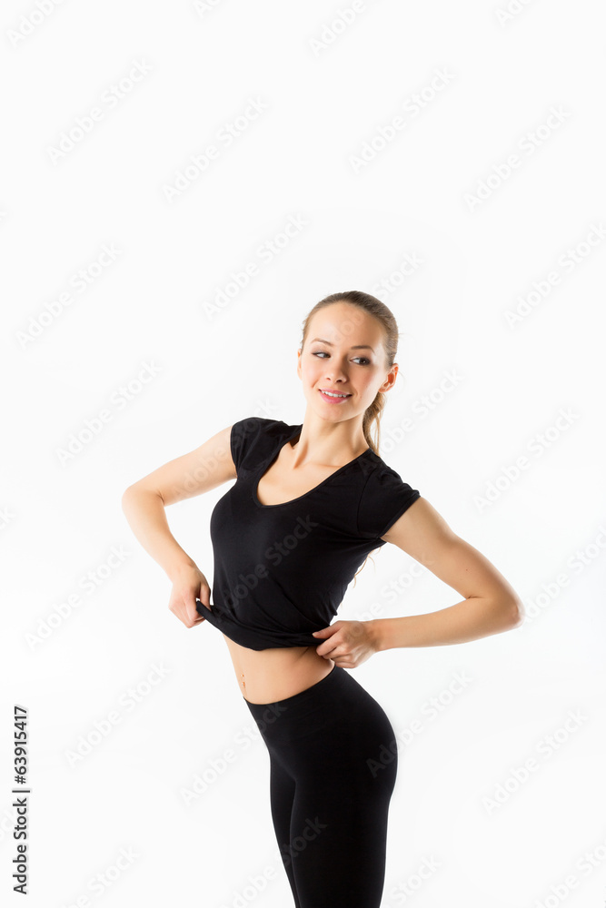 Young woman fitness. Smiles and raises black sports jersey Young woman fitness. Smiles and raises black sports jersey