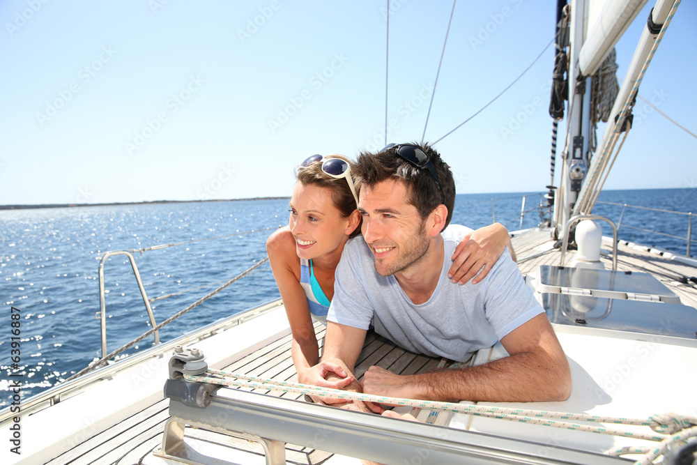 Obraz premium Couple relaxing on sailboat deck