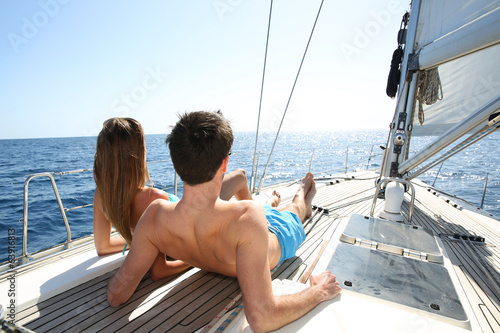 Lucky couple relaxing on sailboat deck © goodluz