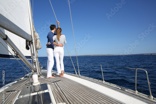 Fancy couple enjoying sailing on a beautiful sailboat © goodluz