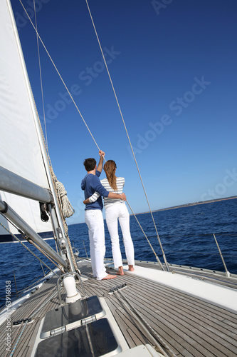 Fancy couple enjoying sailing on a beautiful sailboat