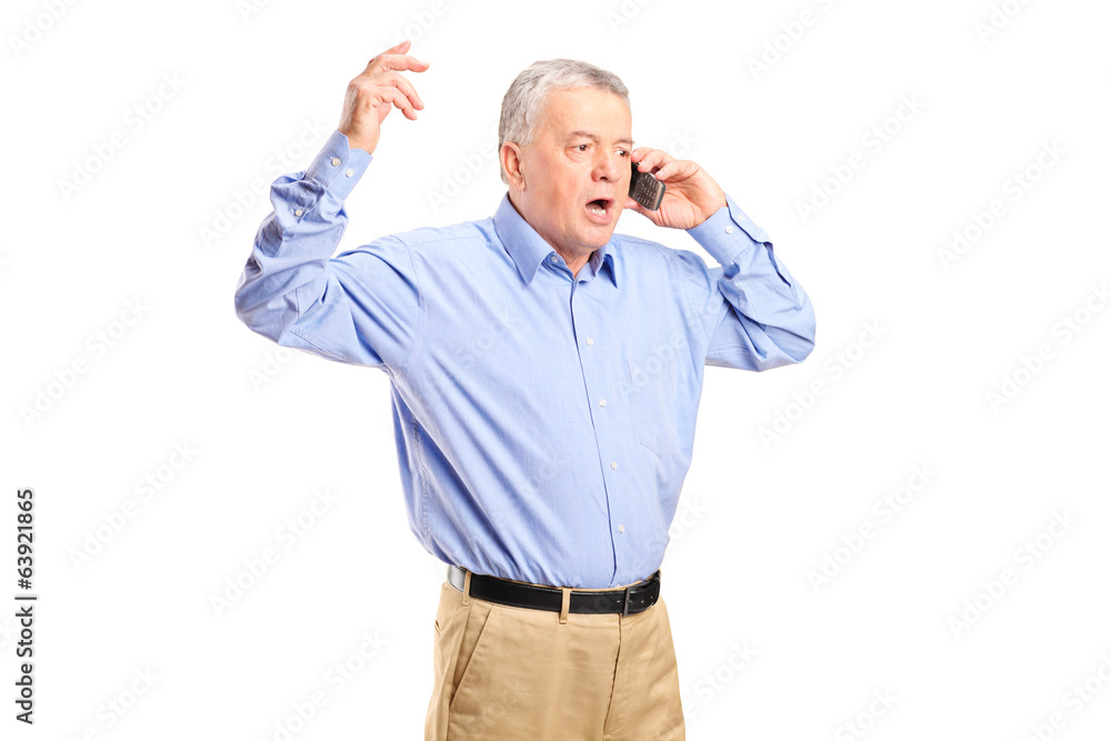 Angry mature man talking on the phone Angry mature man talking on the phone
