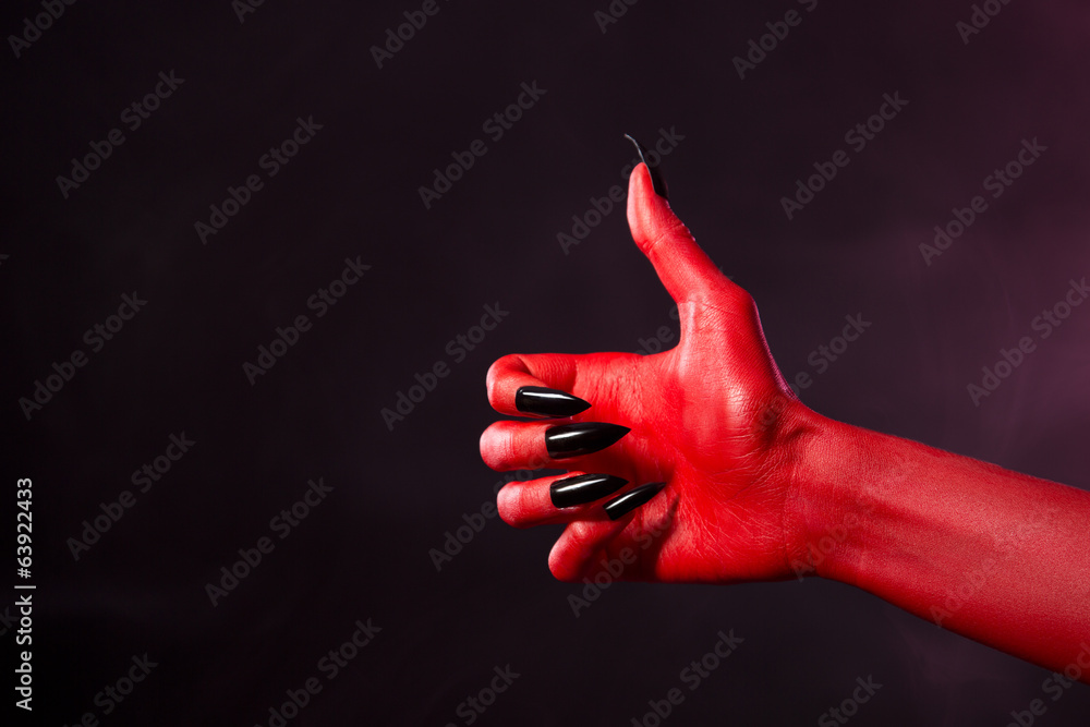 Fototapeta premium Spooky red devil hand showing thumbs up