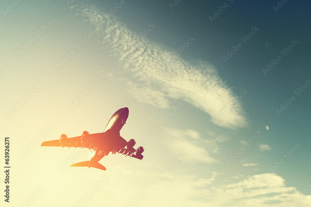 Fototapeta premium Samolot startuje o zachodzie słońca. Sylwetka latającego samolotu