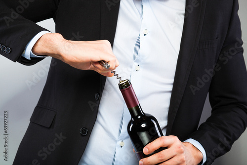 Canvas-taulu Handsome man opening bottle of wine