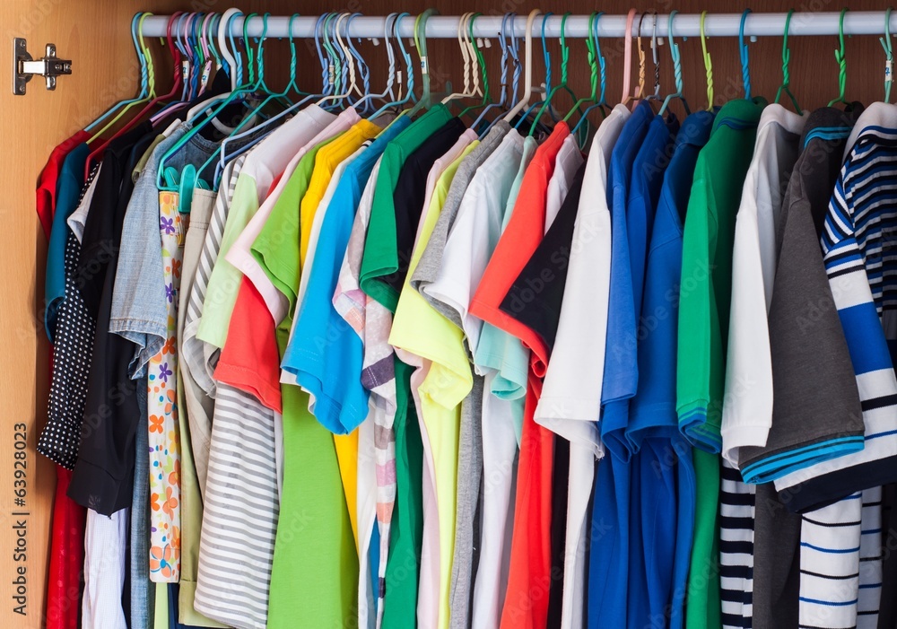 colorful t-shirts hanging in wardrobe.