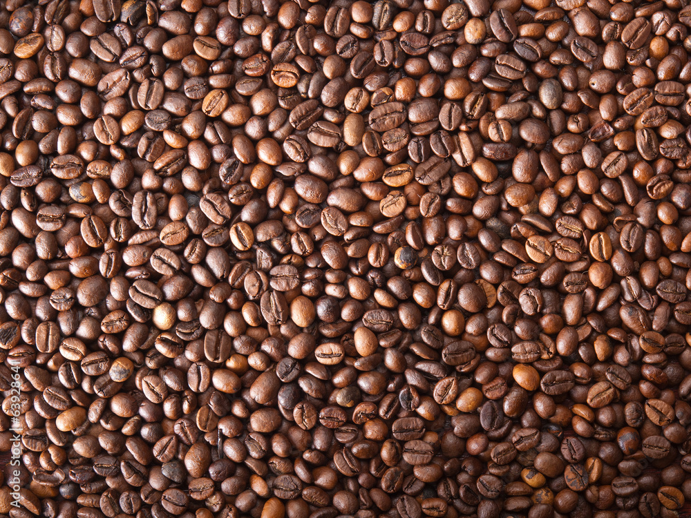 Numerous coffee beans which have been scattered all over the sur Numerous coffee beans which have been scattered all over the sur