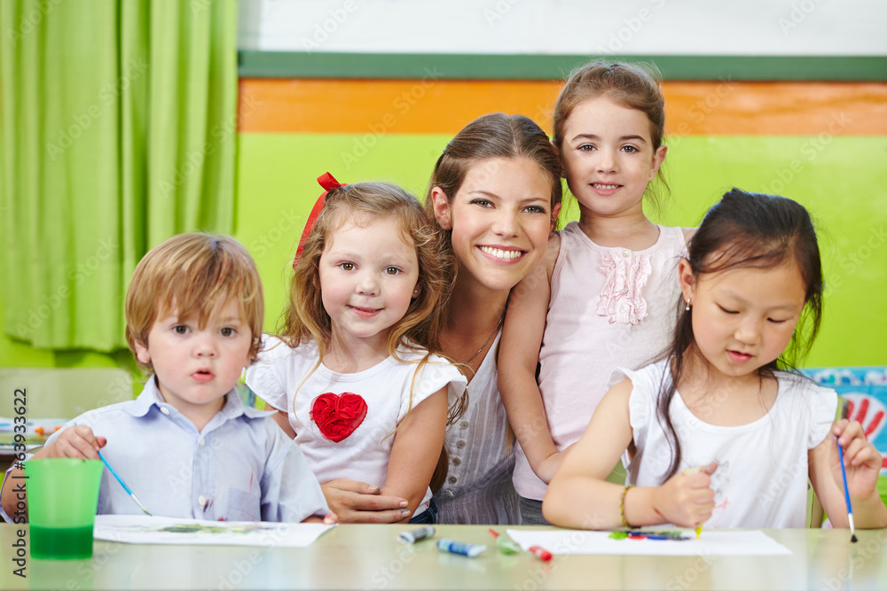 Lachende Frau und Kinder in Kindergarten Lachende Frau und Kinder in Kindergarten
