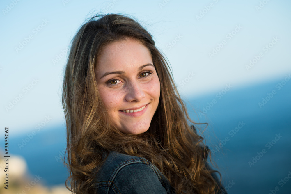 isolated portrait of a cheerful young women by the sea in summer