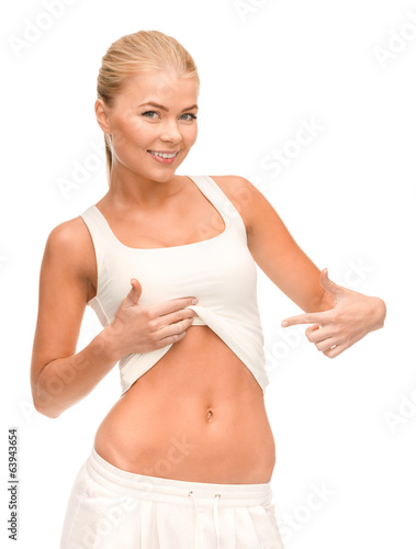 beautiful sporty woman pointing at her abs