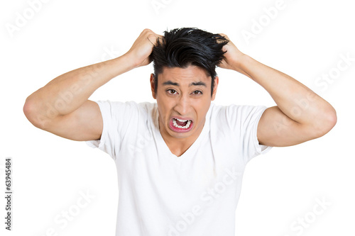 Headshot Stressed, upset, screaming young man pulling out hair