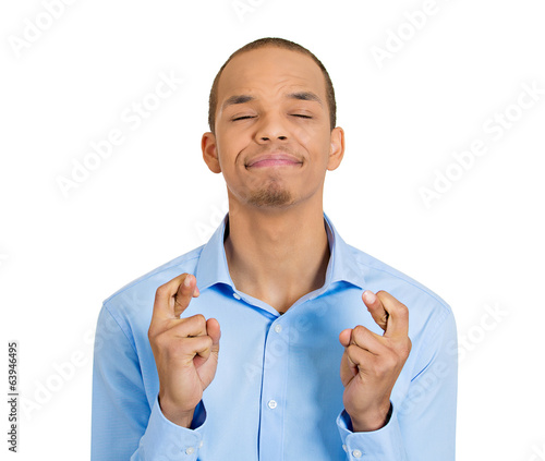 Young man crossing fingers, isolated on white background 