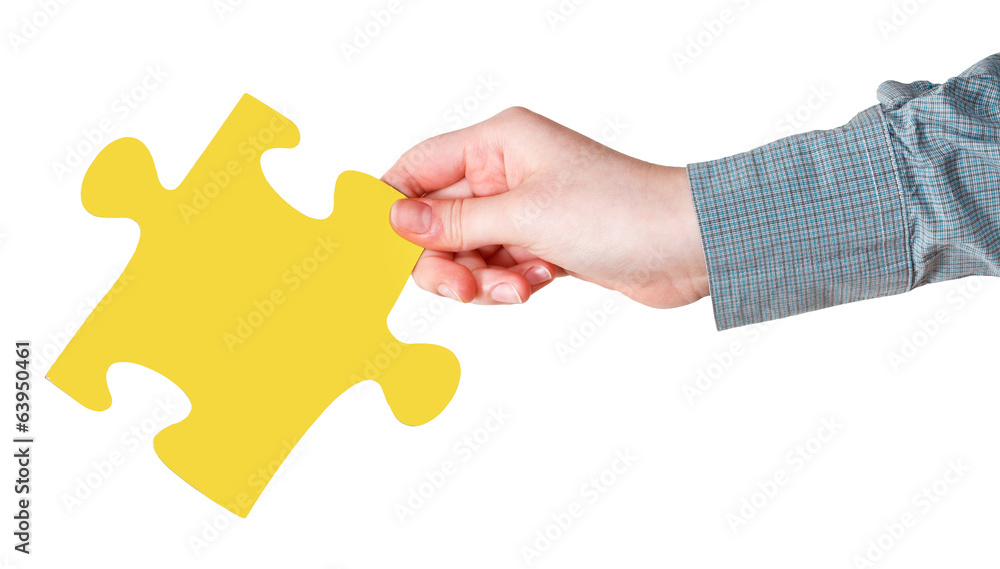 female hand with yellow puzzle piece female hand with yellow puzzle piece