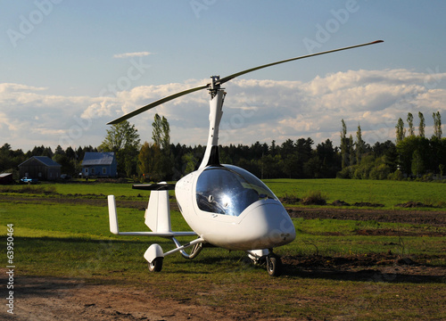 White gyroplane parked on the private airfield