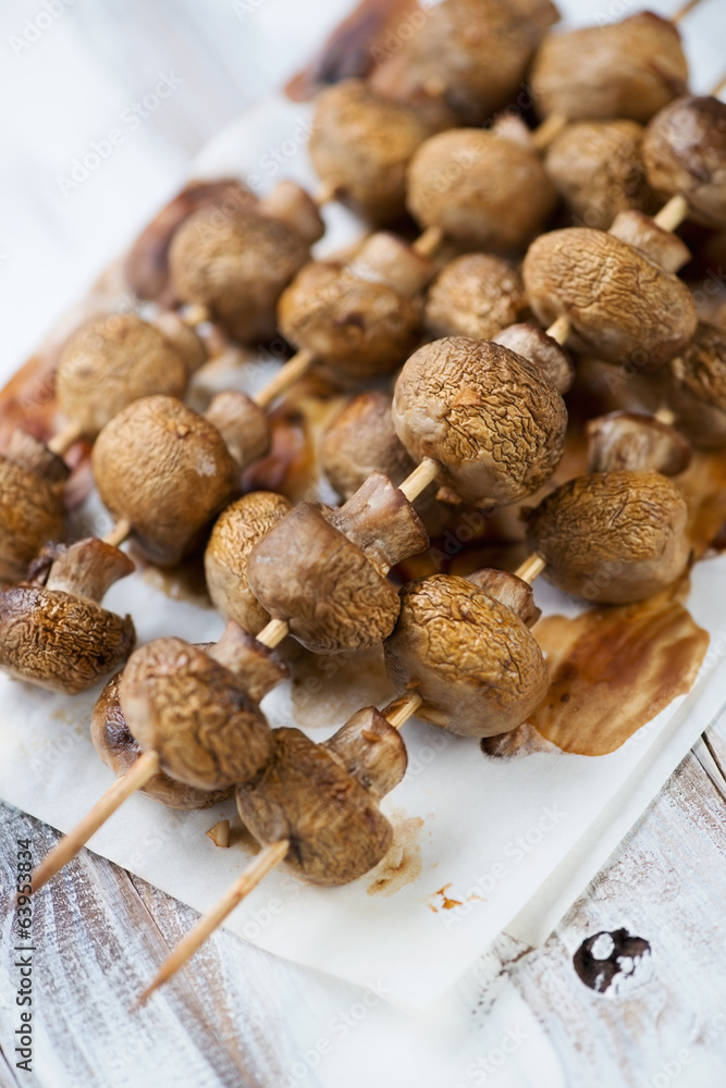 Baked champignons skewers, vertical shot, close-up Baked champignons skewers, vertical shot, close-up