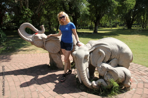 девушка на фоне статуй слонов