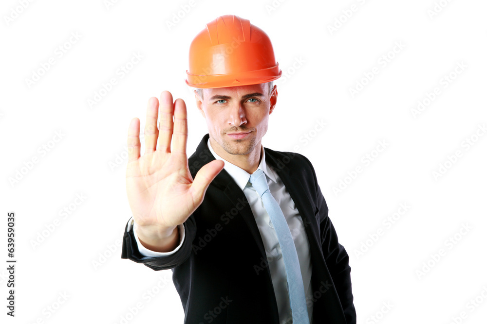 Confident businessman in helmet showing stop gesture Confident businessman in helmet showing stop gesture