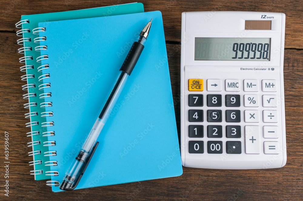 Calculator with notebook & pen on wooden background Calculator with notebook & pen on wooden background