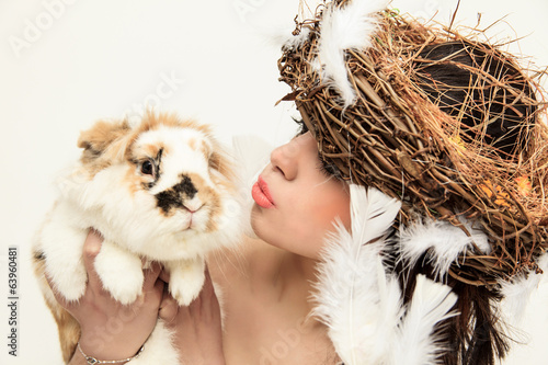 Frau mit Osterdekoration knuddelt einen Hasen photo
