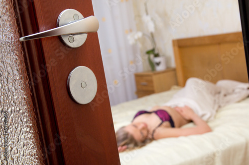 voyeurism - woman in lingerie - view  through bedroom door photo