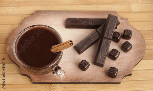 Hot chocolate in a glass cup and chocolate bars.