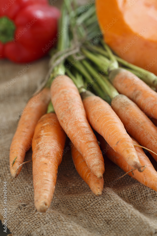 Fresh carrot with green tops and other vegetables Fresh carrot with green tops and other vegetables