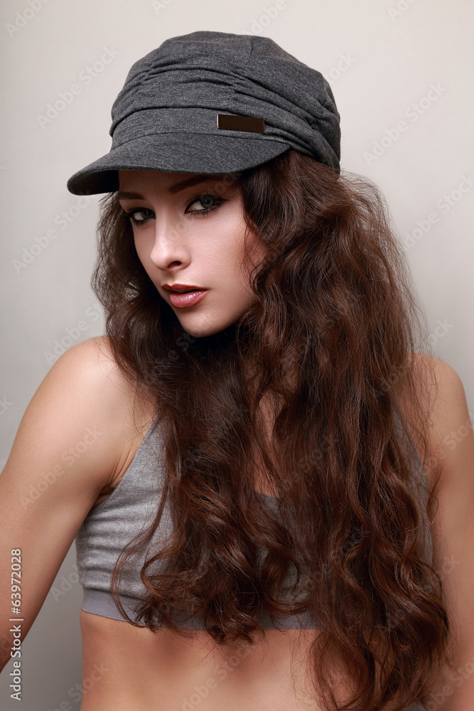 Beautiful long hair trendy woman in cap. Hip-hop style Beautiful long hair trendy woman in cap. Hip-hop style