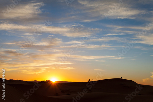 Silhouette of photographers in desert Sahara at sunset, Morocco