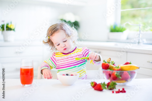 Little toddler girl having fruit for breakfast