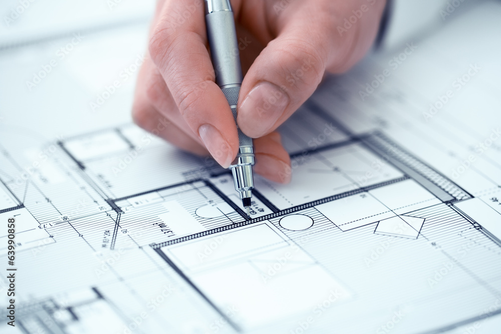 Woman Architect drawing on print construction project Woman Architect drawing on print construction project