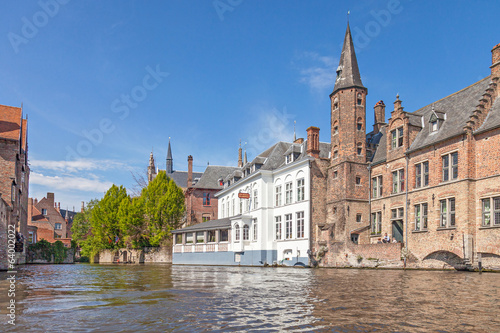 Ancient red brick building with little tower in Bruges
