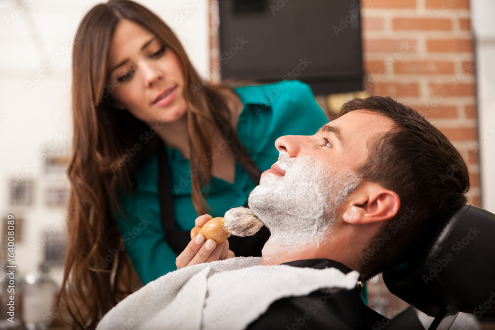 Female barber shaving a man Female barber shaving a man