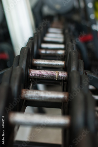 Row of Hand Barbells weight training equipment in gym room