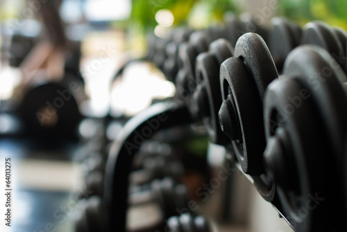 Row of Hand Barbells weight training equipment in gym room