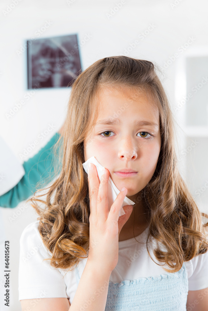 Girl with toothache,doctor holding and looking at x-ray of teeth Girl with toothache,doctor holding and looking at x-ray of teeth