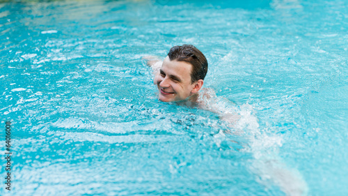 Young man swimming in pool © Valeri Luzina