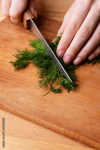 Chopped dill on wooden board close-up