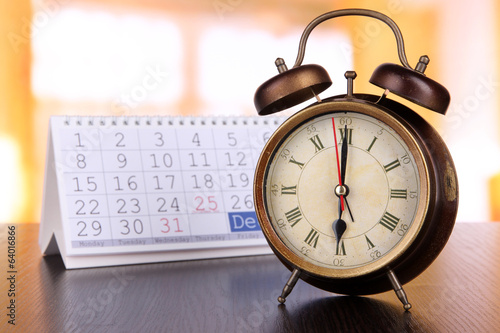Alarm clock and calendar on bright background