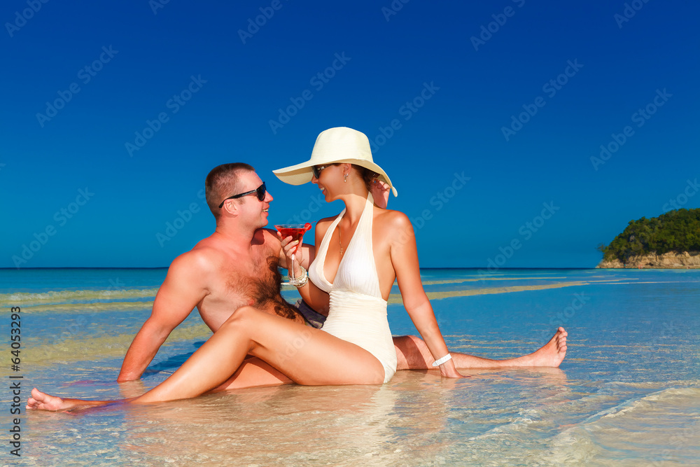young couple in love at the tropical beach and enjoying cocktail young couple in love at the tropical beach and enjoying cocktail