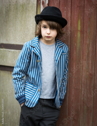 Boy with Hat Leaning Against the Wall photo