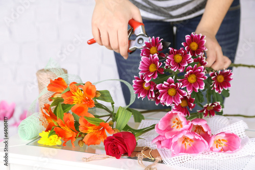 Fototapeta Naklejka Na Ścianę i Meble -  Female hands composing beautiful bouquet, close-up. Florist at