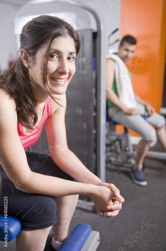 Two persons relaxing at gym on machines